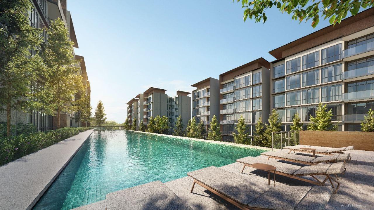Pool deck at Amberwood at Holland with a long lap pool running between six-storey residential blocks and timber sun loungers on the deck